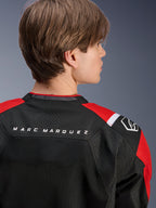 Giacca Alpinestars MM93 T-SPS Air V2, vista posteriore della parte superiore della schiena e delle spalle, nero con dettagli rosso brillante e bianco, scritta 'MARC MARQUEZ' sullo sprone, caratterizzata da pannelli in rete tecnica e logo sulla spalla, abbigliamento moto urban sport