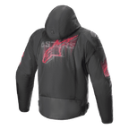 Giacca Alpinestars Zaca Air Venom WP, nero e rosso brillante, vista posteriore con un grande logo rosso stilizzato sulla schiena, giacca da moto in tessuto con pannelli in rete 3D, cappuccio rimovibile e slider sulle spalle DFS Lite, abbigliamento tecnico sportivo.