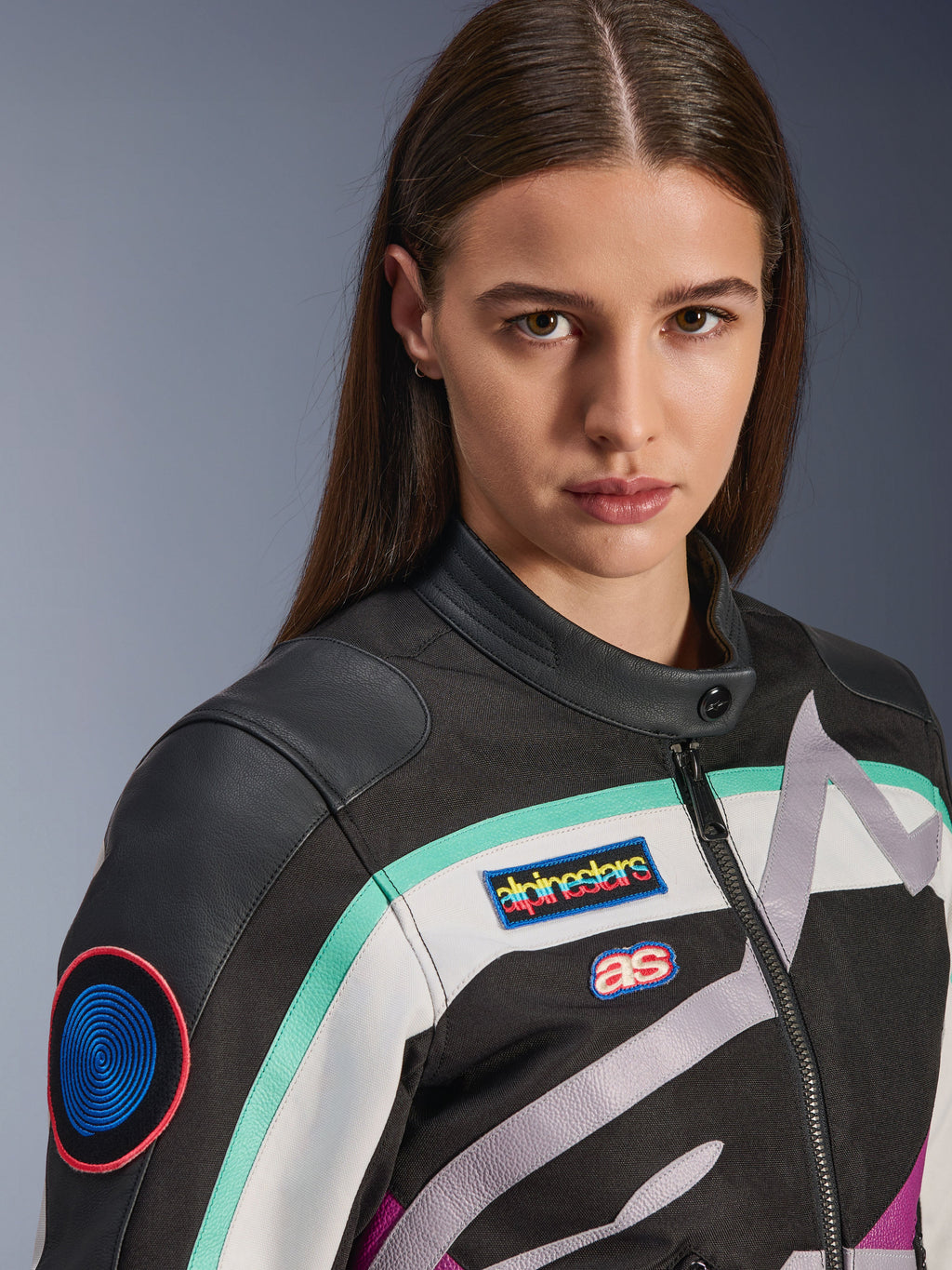 Giacca da donna Alpinestars Idles, giacca da moto, nero, bianco sporco e viola con accenti color ottanio, primo piano con patch colorate Alpinestars heritage e dettagli in pelle di capra sulle spalle, design d'ispirazione vintage per la guida urbana