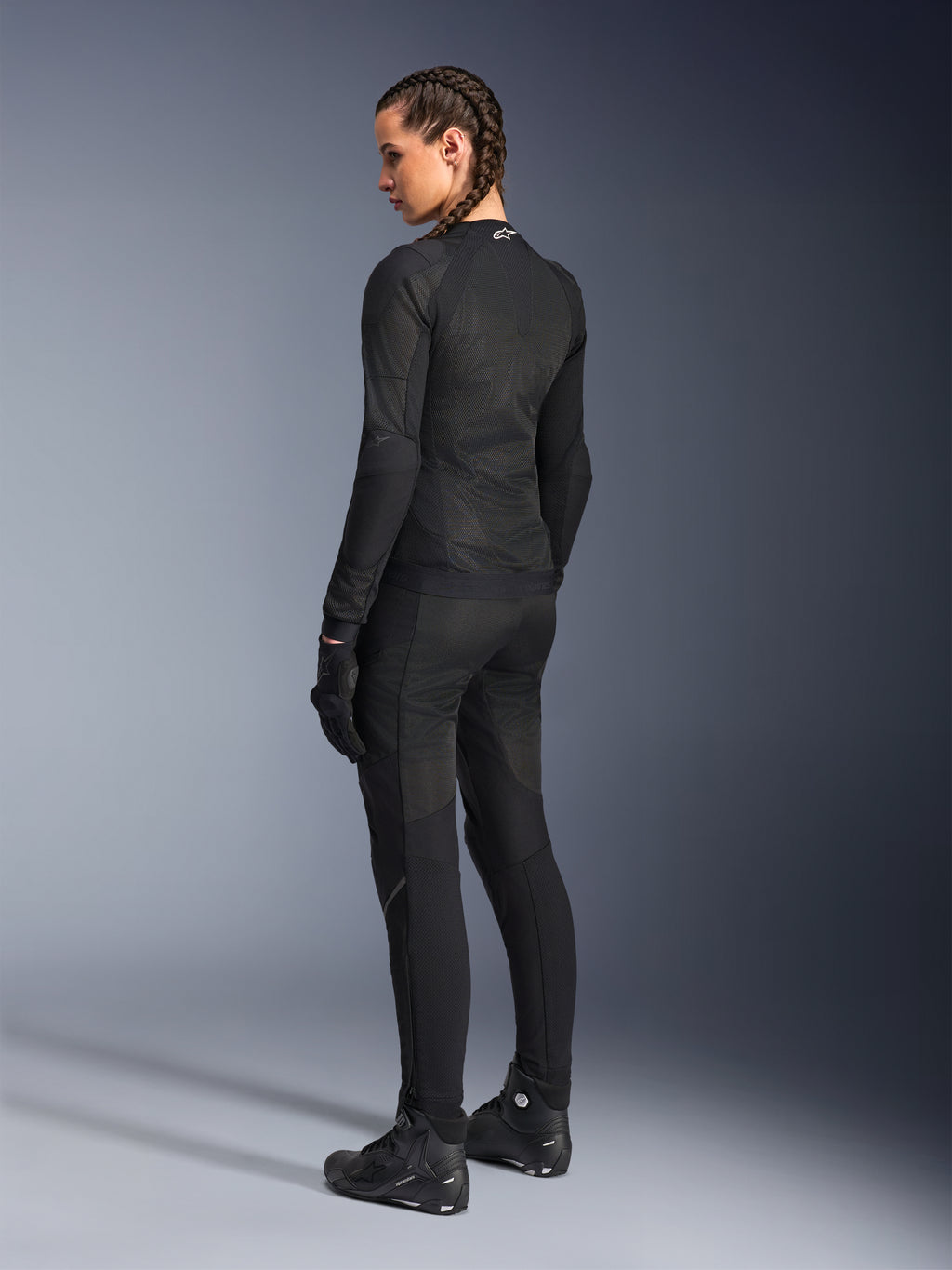 Alpinestars Giacca Stella Troop-Air da donna, nero, vista posteriore, indossata con pantaloni da moto, guanti e stivali coordinati neri, costruzione in mesh tecnico slim-fit per la guida urbana