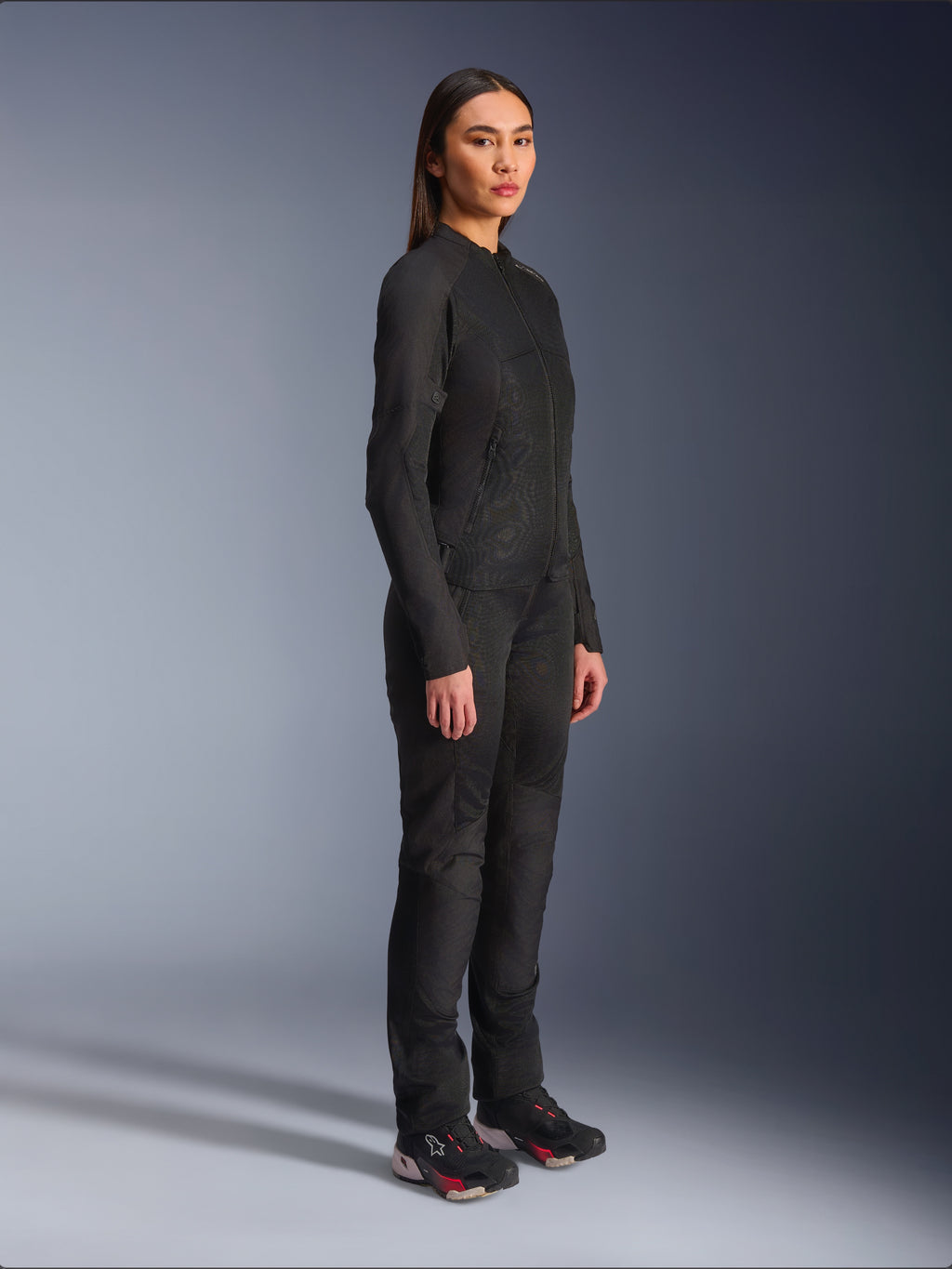 Giacca Alpinestars Stella C-1 Air da donna in nero, giacca da moto in tessuto con pannelli in rete, indossata con pantaloni da guida neri coordinati e sneakers tecniche, scatto in studio che mostra un outfit completo per la guida urbana