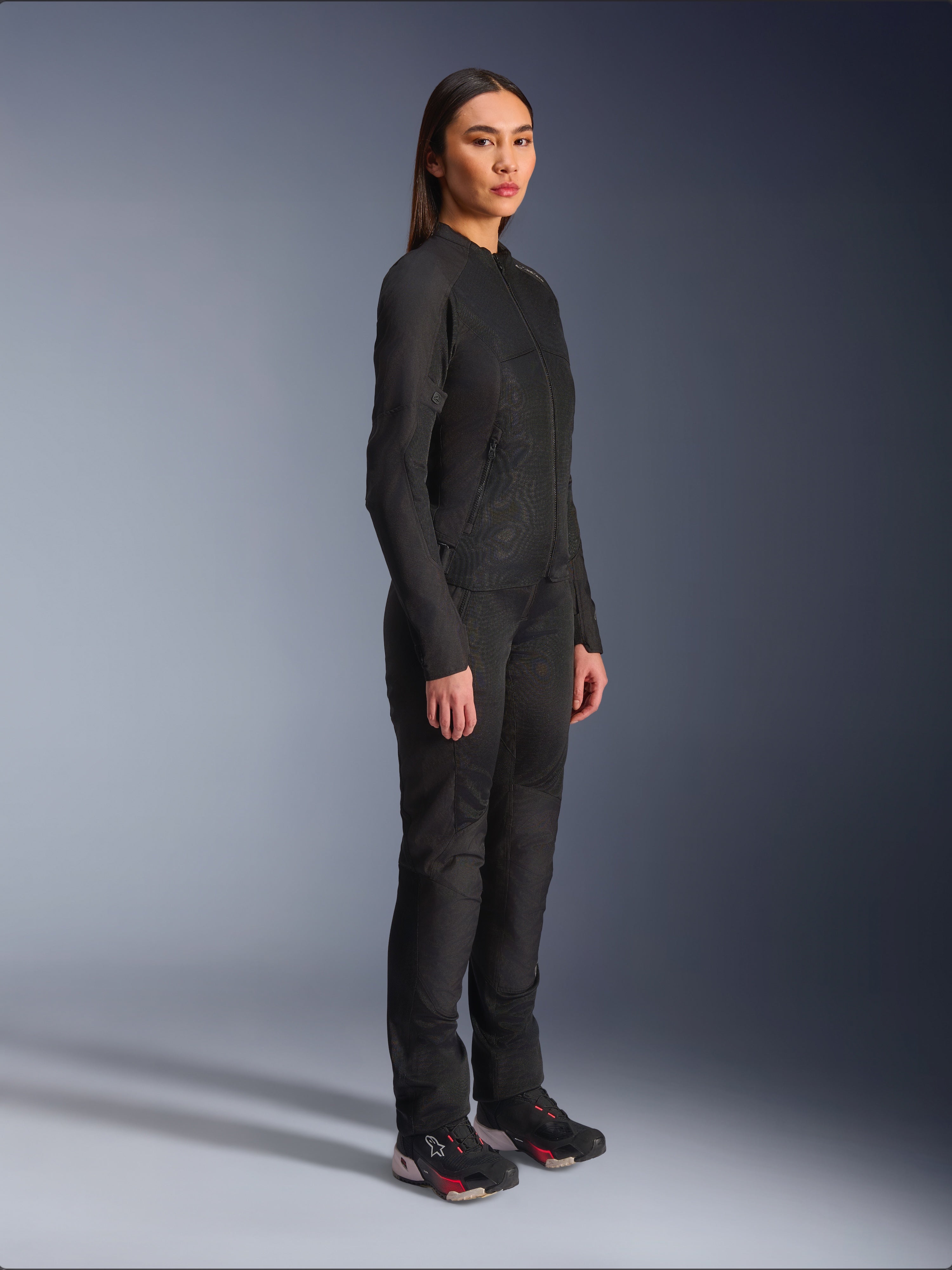Giacca Alpinestars Stella C-1 Air da donna in nero, giacca da moto in tessuto con pannelli in rete, indossata con pantaloni da guida neri coordinati e sneakers tecniche, scatto in studio che mostra un outfit completo per la guida urbana