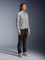 Donna che indossa la giacca Alpinestars Stella C-1 Air in Silver, giacca da moto leggera in tessuto e mesh, abbinata a pantaloni da moto neri e sneaker casual, estetica urban riding pulita.