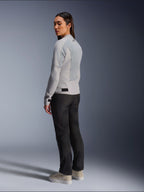 Donna che indossa la giacca Alpinestars Stella C-1 Air in Silver, vista posteriore e laterale che mostra i pannelli in rete tecnica e il logo riflettente sulla spalla, abbinata a pantaloni da moto neri e sneaker beige, estetica urban riding contemporanea