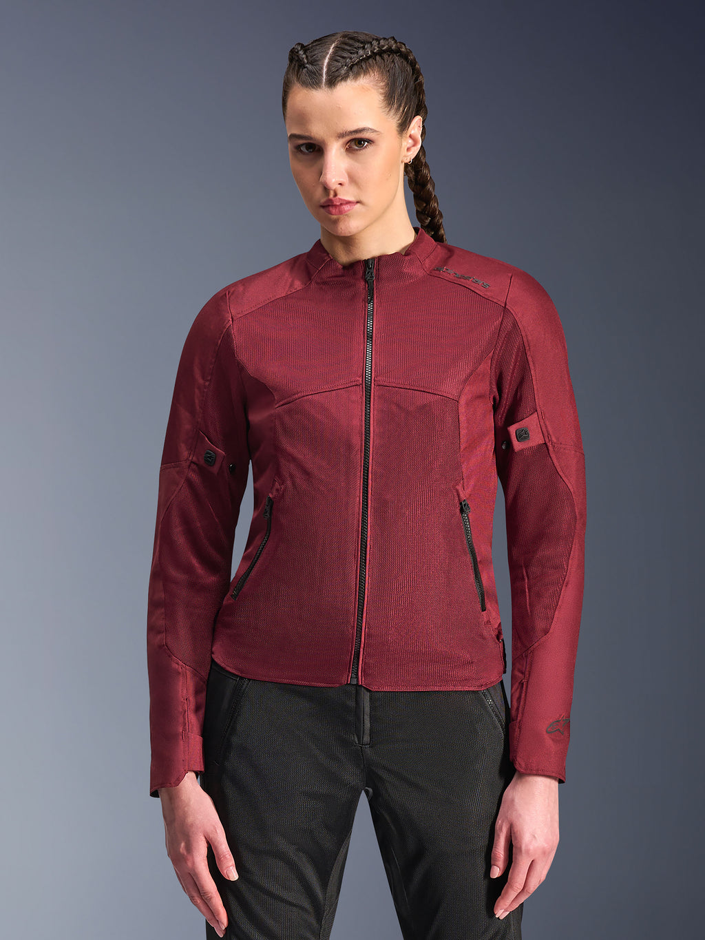 Alpinestars Stella C-1 Air Jacket, giacca da moto da donna, rosso bordeaux, pannelli in rete per la ventilazione, zip frontale e tasche con cerniera, design sportivo sagomato, indossata da una modella con pantaloni da guida neri
