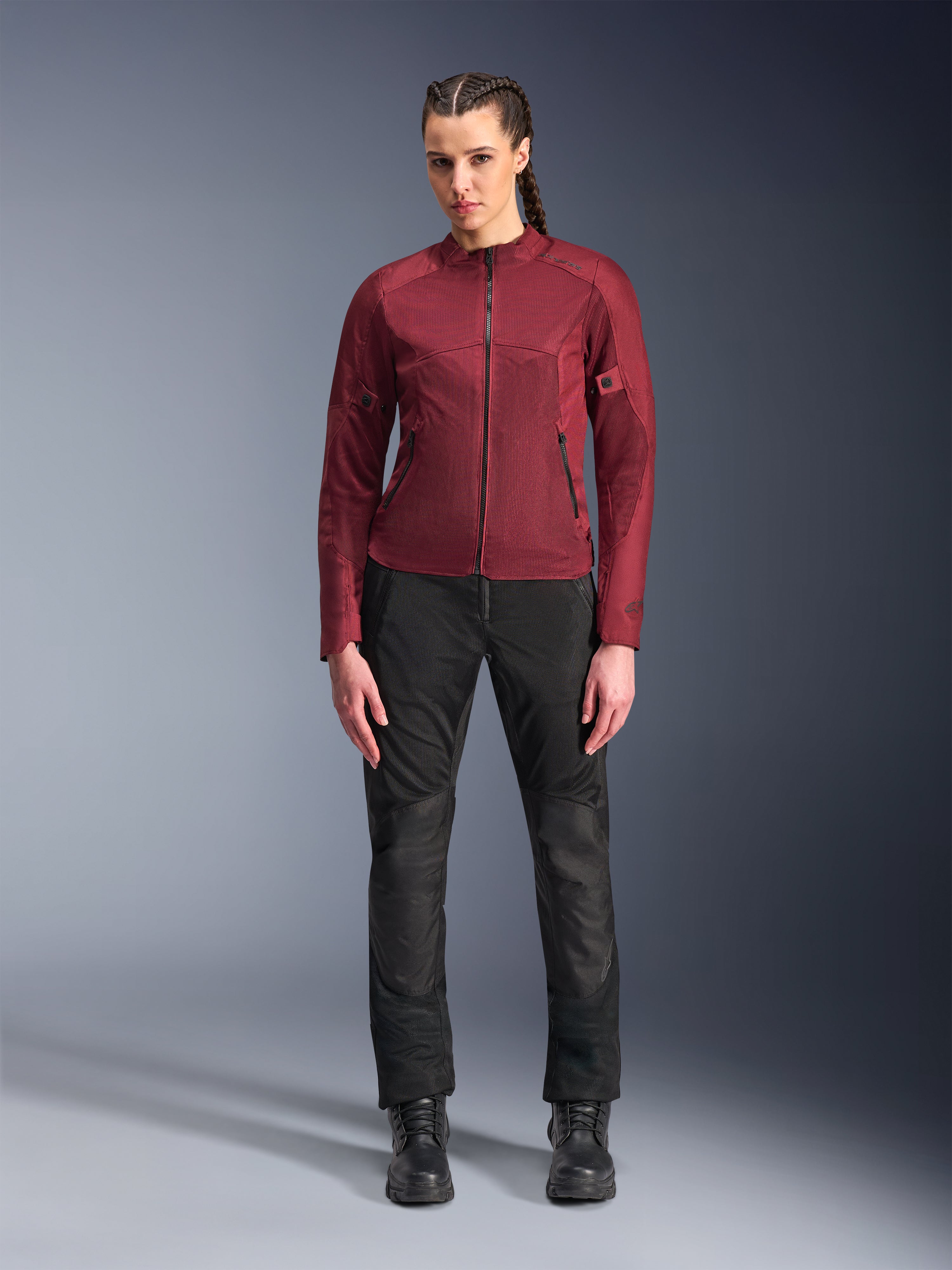Pantaloni Alpinestars Stella C-1 Air, pantaloni da moto da donna per uso urbano, neri, con costruzione in tessuto e mesh, abbinati a una giacca Stella C-1 Air bordeaux e stivali in pelle neri, stile di guida urbano pulito e moderno
