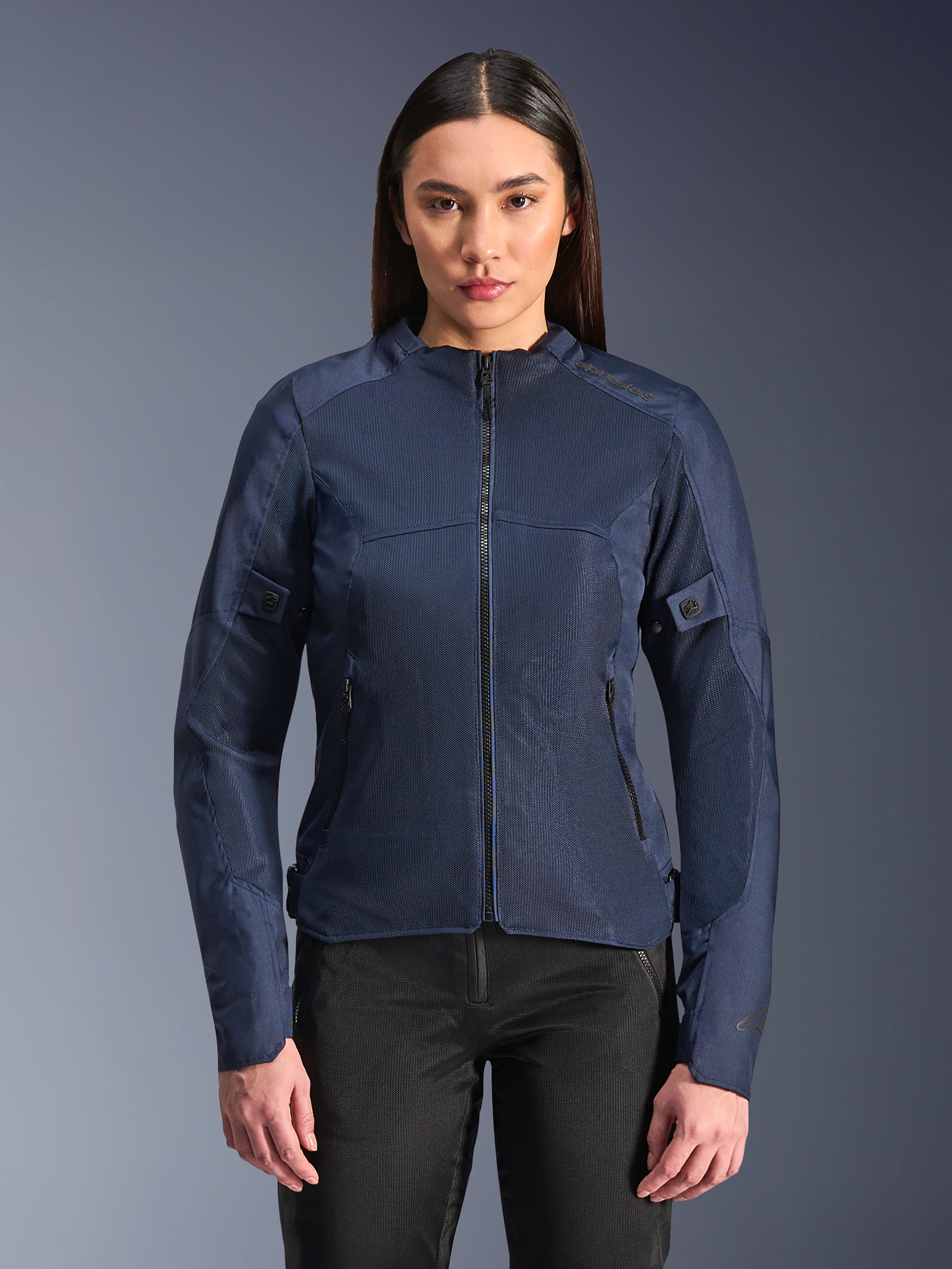 Alpinestars Stella C-1 Air Jacket in blu, giacca da moto da donna, indossata con pantaloni da guida neri, ampi pannelli in rete per il flusso d'aria, tasche frontali e laterali con zip, design moderno e pulito