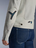 Giacca da donna Alpinestars Stella Circal-1 Air, grigio Metal Gray e blu Methyl Blue, dettaglio ravvicinato di schiena e manica con pannelli in rete per il flusso d'aria, accenti blu neon su gomito e vita e linguetta regolabile, indossata con jeans in denim blu scuro