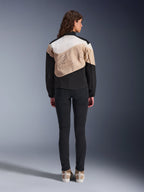 Giacca Alpinestars Stella Moshell, giacca da moto urbana da donna, vista posteriore, design asimmetrico Black Sand e Off White con profilo grafico grande, indossata con pantaloni neri slim-fit e sneaker color sabbia, abbigliamento per guida urbana