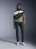 Giacca Alpinestars Stella Moshell, giacca da moto da donna, nero, grigio e bianco sporco con accenti rosa, indossata da una modella con jeans scuri e sneakers bianco sporco, caratterizzata da un design con zip asimmetrica e grafiche geometriche audaci, abbigliamento urbano contemporaneo