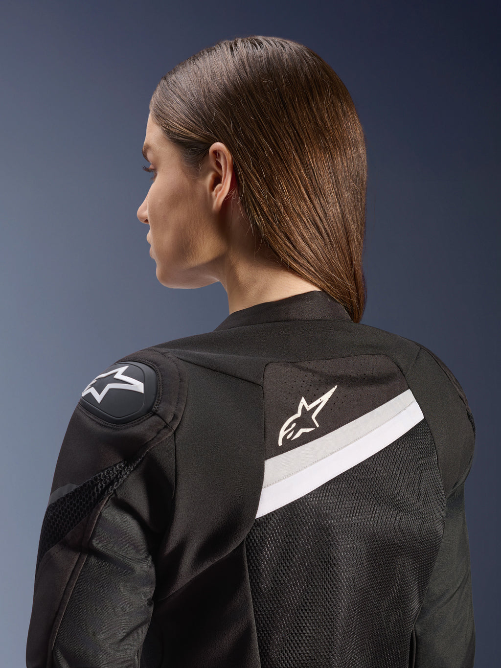 Giacca Alpinestars Stella T-GP Plus R V4 Airflow, giacca da moto sportiva da donna, nero e bianco, con pannelli in mesh sulla schiena e accenti bianchi, logo Alpinestars sulla spalla e sulla schiena, vestibilità anatomica per guida sportiva