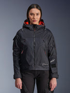 Alpinestars Molly Air Jacket, giacca da moto urban da donna, nera con fodera interna Fluo Coral, indossata da una modella, design con cappuccio in tessuto tecnico, tasche con cerniera e logo Alpinestars sulla manica