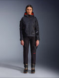 Pantaloni da donna Alpinestars Actea, pantaloni da moto neri con scritte rosse e tasche cargo, indossati da una motociclista con giacca nera con cappuccio, abbigliamento moto urban moderno