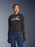 Donna che indossa la giacca Alpinestars Stella SMX Air, nero bianco rosso fluo, giacca da moto in tessuto con rete ventilata e logo bianco sul petto, abbinata a jeans blu e guanti da guida neri, vestibilità femminile per la guida sportiva