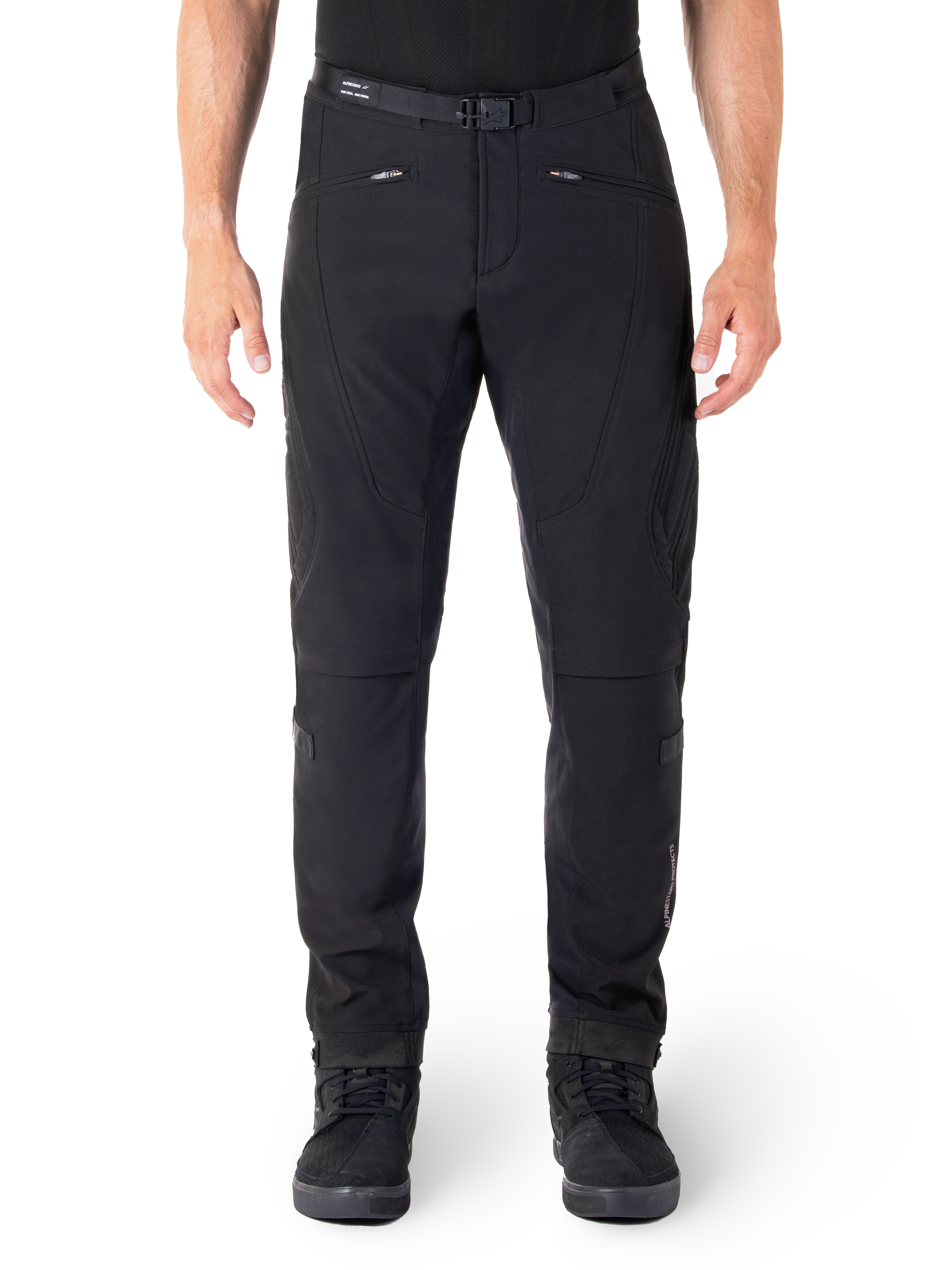 Pantaloni Alpinestars Alden, pantaloni neri da moto urban, vista frontale, tessuto softshell tecnico elasticizzato, cintura integrata con fibbia magnetica, tasche anteriori con cerniera, dettagli trapuntati sulle ginocchia, silhouette slim-fit, abbinati a scarpe da moto nere