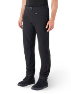 Pantaloni Alpinestars Alden, pantaloni da moto urban, nero, tessuto tecnico softshell con vestibilità regolare, caratterizzati da fibbia magnetica in vita, pannelli laterali trapuntati, tasche con zip e logo discreto sulla parte inferiore della gamba, indossati con scarpe da moto nere