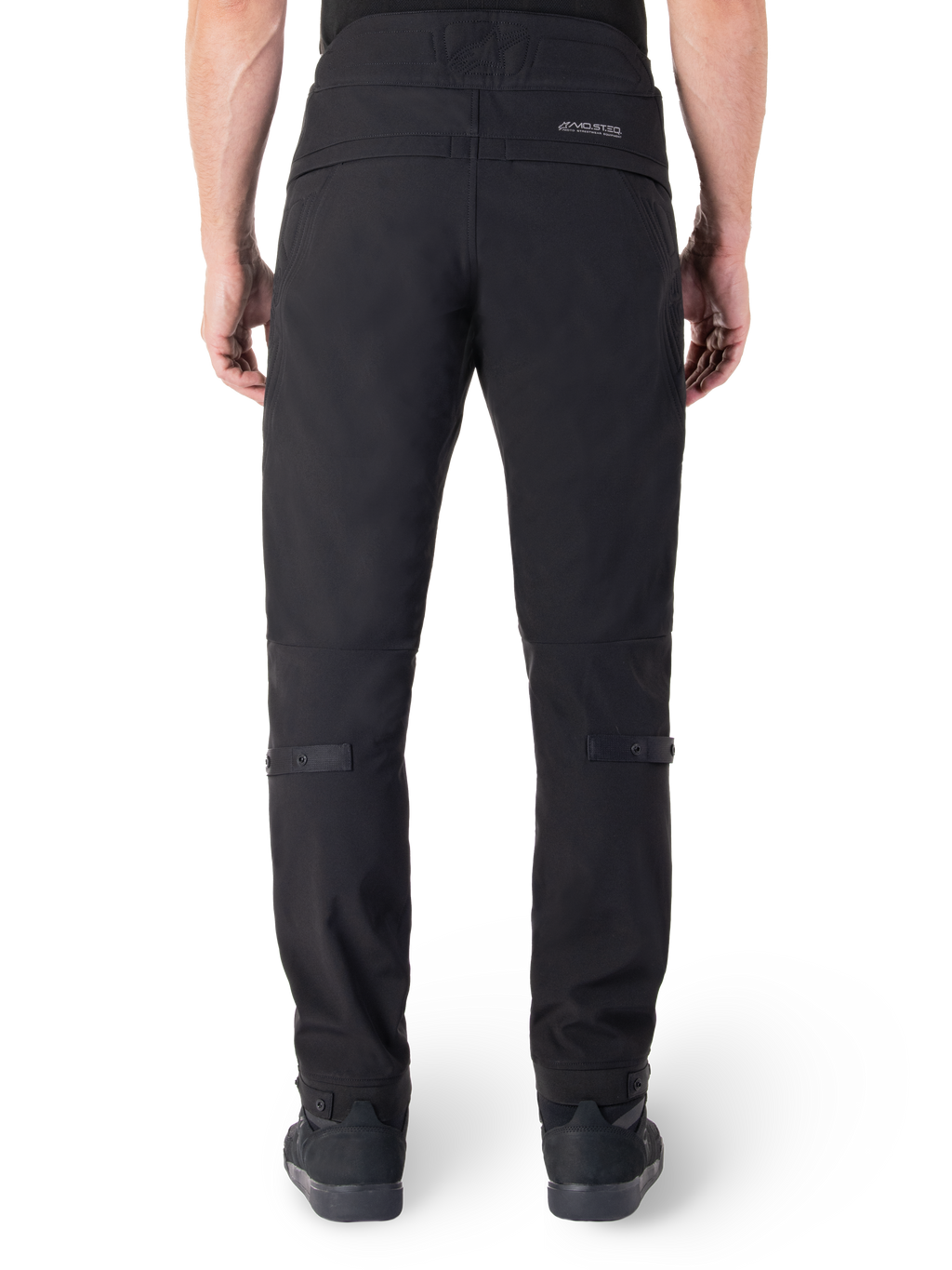 Pantaloni Alpinestars Alden, pantaloni da moto urbani neri, vista posteriore, con marchio MO.ST.EQ. riflettente sul carré posteriore, vestibilità aderente sotto il ginocchio e regolatori di volume con bottoni a pressione su polpacci e caviglie, design in tessuto tecnico ispirato allo streetwear.