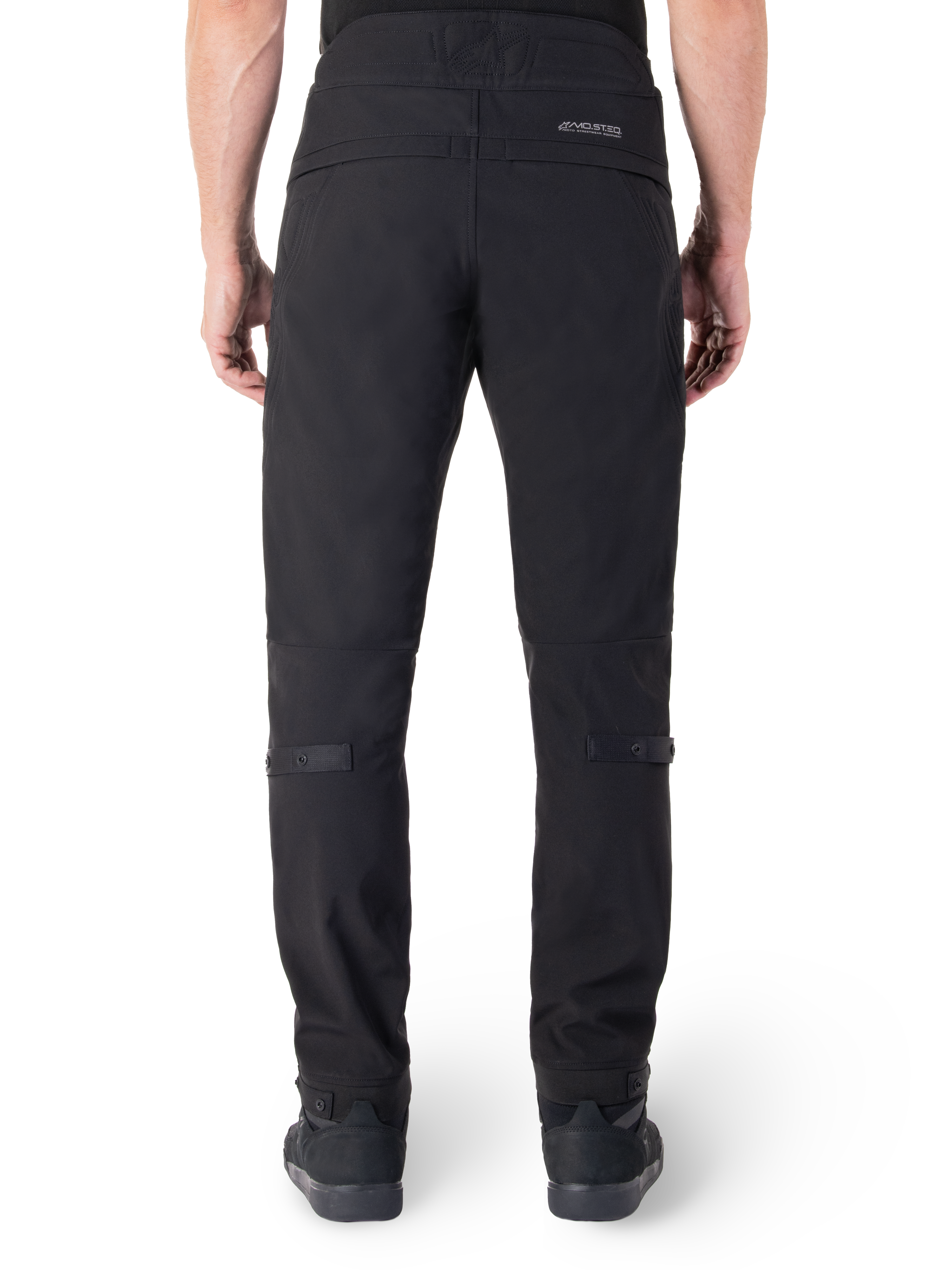Pantaloni Alpinestars Alden, pantaloni da moto urbani neri, vista posteriore, con marchio MO.ST.EQ. riflettente sul carré posteriore, vestibilità aderente sotto il ginocchio e regolatori di volume con bottoni a pressione su polpacci e caviglie, design in tessuto tecnico ispirato allo streetwear.
