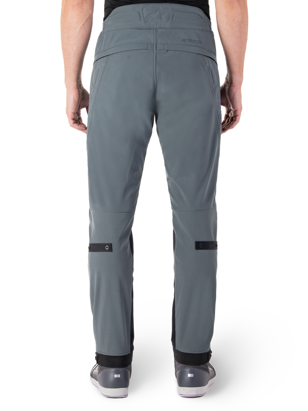 Alpinestars Pantaloni Alden, Urban Gray, vista posteriore di pantaloni da moto urban da uomo, vestibilità aderente sotto il ginocchio con cinturini di regolazione neri sul polpaccio, design a vita alta con marchio MO.ST.EQ. sul carré posteriore, indossati con scarpe da moto grigie