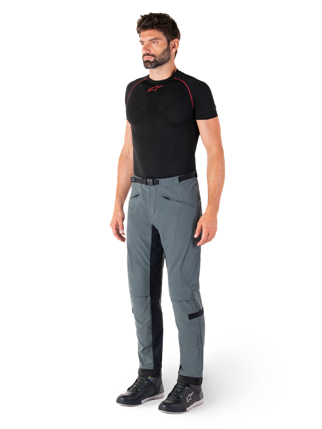 Pantaloni Alpinestars Alden, pantaloni tecnici da moto in grigio Urban Gray, con pannelli laterali trapuntati e tessuto elasticizzato nero all'interno gamba, abbinati a un base layer nero e scarpe da moto, abbigliamento urbano ispirato allo streetwear