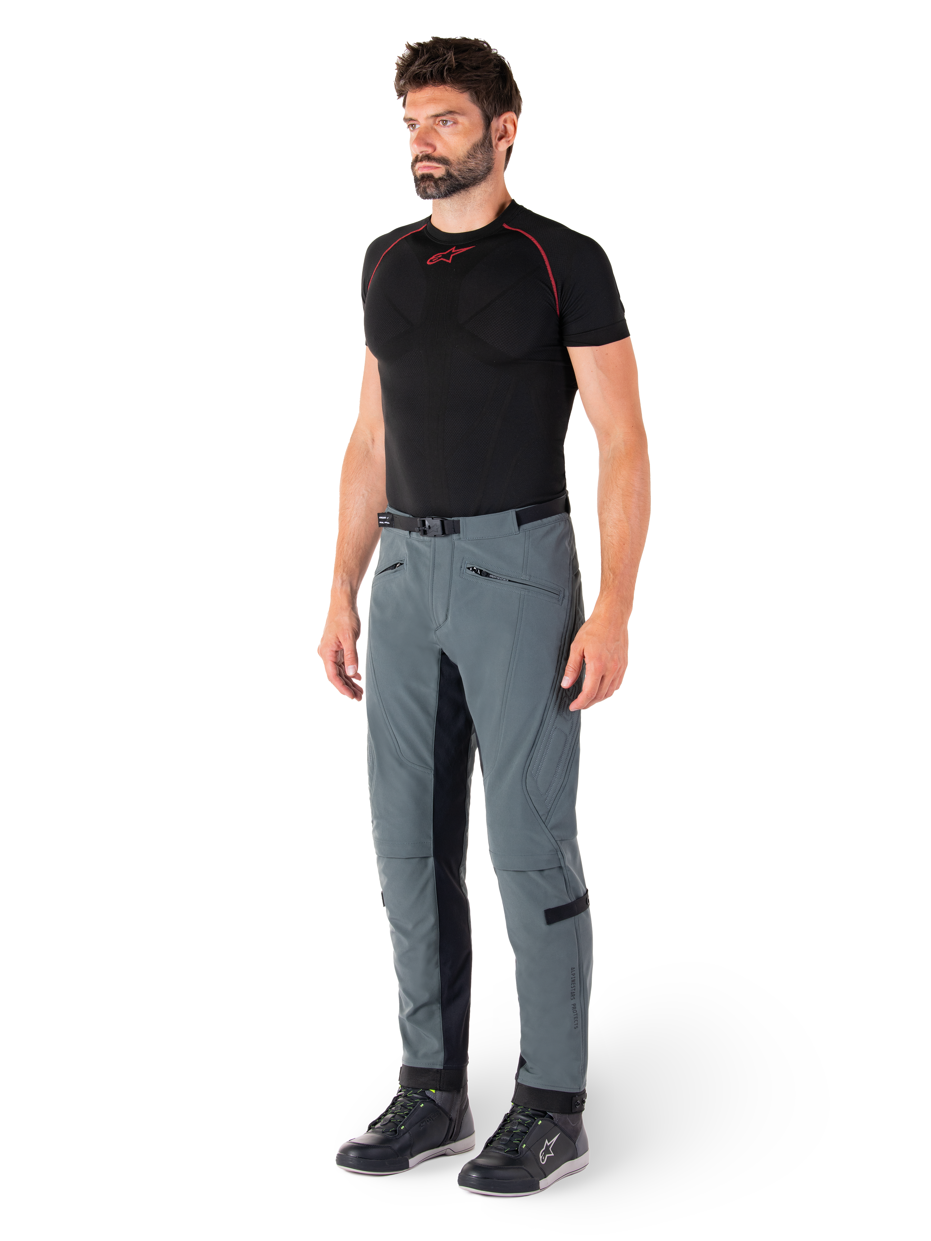 Pantaloni Alpinestars Alden, pantaloni tecnici da moto in grigio Urban Gray, con pannelli laterali trapuntati e tessuto elasticizzato nero all'interno gamba, abbinati a un base layer nero e scarpe da moto, abbigliamento urbano ispirato allo streetwear