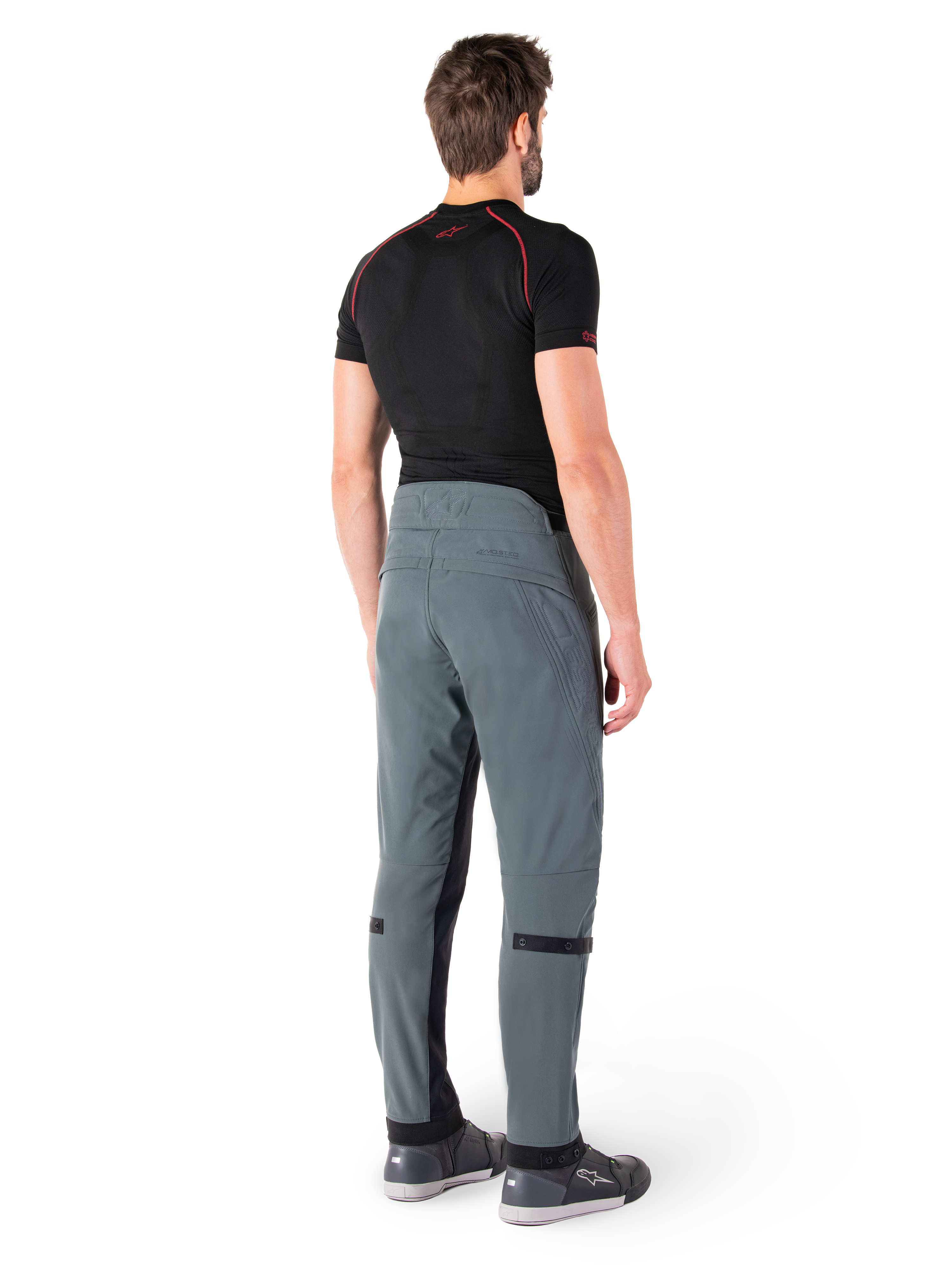 Alpinestars Alden Pants, Urban Gray, vista posteriore, pantaloni da moto in tessuto tecnico con dettagli trapuntati sulla parte superiore della vita posteriore e sulle gambe, abbinati a un base layer nero e scarpe da moto grigie, stile streetwear urbano contemporaneo