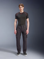 Alpinestars Flex-AST Cargo Pants, neri, pantaloni da moto urbani indossati da un modello con una maglia nera a maniche corte e sneakers, caratterizzati da vestibilità regular tapered, tasche cargo e dettaglio della fibbia della cintura integrata