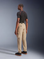 Alpinestars Flex-AST Cargo Pants - Short, pantaloni da moto urban in beige chiaro, vista posteriore di tre quarti con tasche cargo laterali e orli elasticizzati, abbinati a una maglia nera a maniche corte e scarpe casual nere