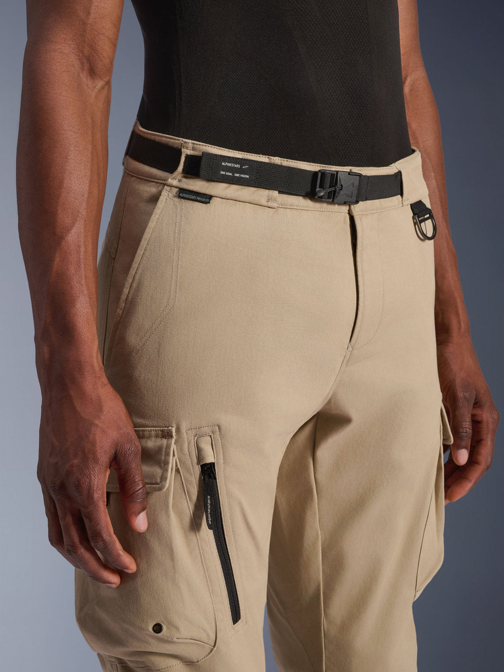 Alpinestars Flex-AST Cargo Pants - Short, beige chiaro, vista ravvicinata della vita e della coscia, con cintura nera regolabile con marchio Alpinestars, anello a D in metallo e tasche cargo funzionali con zip e patte a pressione, abbigliamento moto urban contemporary