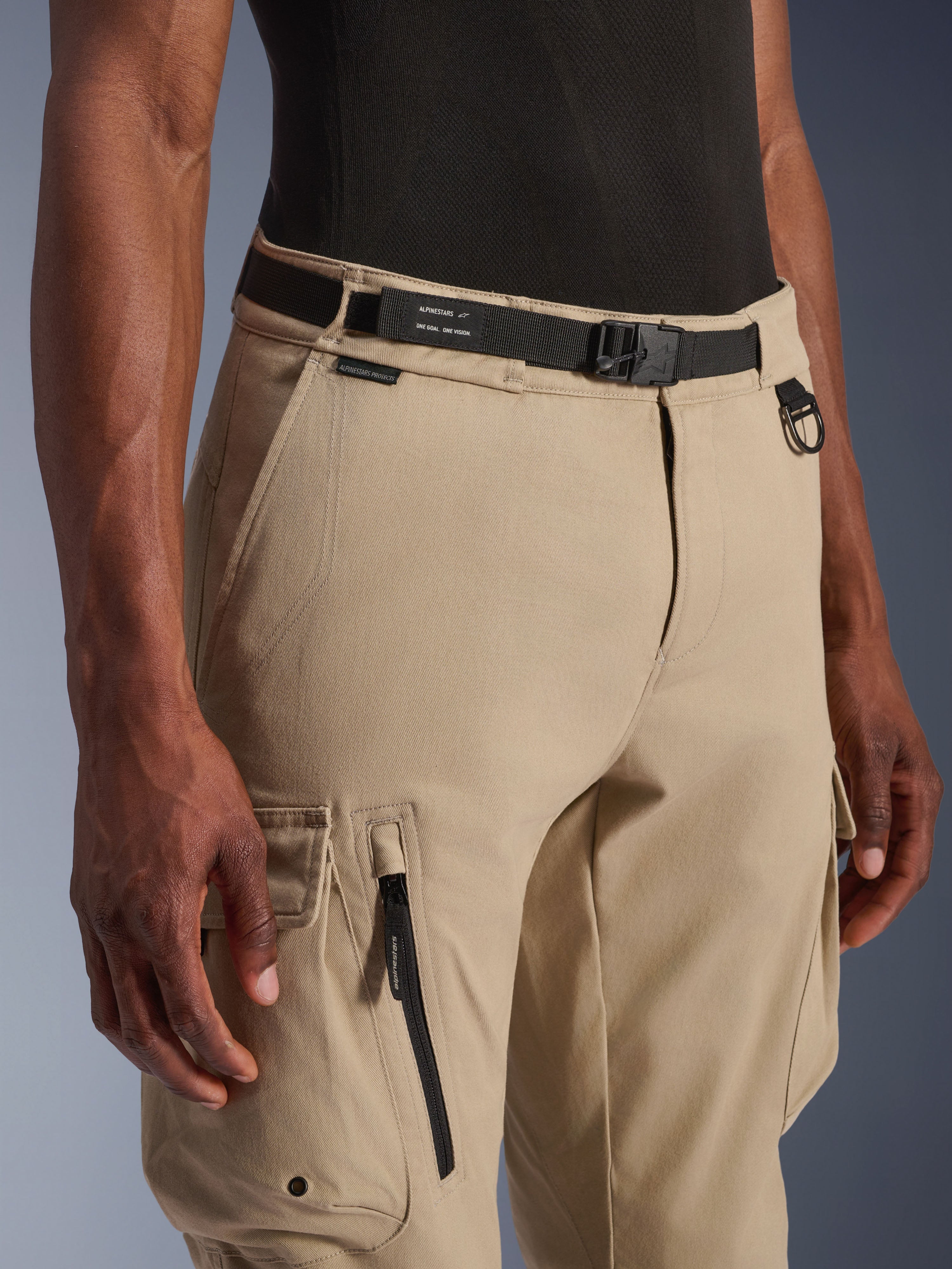 Alpinestars Flex-AST Cargo Pants - Short, beige chiaro, vista ravvicinata della vita e della coscia, con cintura nera regolabile con marchio Alpinestars, anello a D in metallo e tasche cargo funzionali con zip e patte a pressione, abbigliamento moto urban contemporary