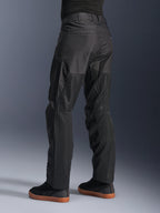 Alpinestars C-1 Air Pants, pantaloni da moto urban, nero, vista posteriore che mostra ampi pannelli in mesh tecnico sulla parte posteriore delle gambe per la ventilazione, design pulito per la guida in città, indossati con sneaker casual nere.