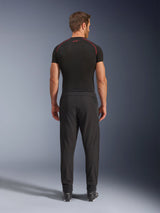 Alpinestars Aeroshell Airflow Pants, pantaloni da moto neri, vista posteriore mostrata su un modello con base layer nero e stivali, con telaio softshell leggero e pannelli in rete integrati per la ventilazione