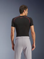 Pantaloni Alpinestars Aeroshell Airflow, Mid Gray, vista posteriore, indossati con un base layer nero a maniche corte con cuciture e logo rossi, caratterizzati da tessuto softshell elastico leggero e pannelli in rete per la massima ventilazione, vestibilità sportiva ergonomica per la guida della moto