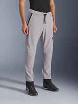 Pantaloni Alpinestars Aeroshell Airflow, grigio medio, pantaloni da moto leggeri con zone di ventilazione traforate al laser su cosce e stinchi, elastico in vita con cordino e vestibilità sportiva slim, indossati da un modello con scarpe da moto nere.