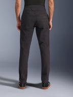 Alpinestars Flex-AST Canvas Pants, pantaloni da moto urban, nero, vista posteriore con tasche posteriori e logo ricamato, vita posteriore allungata e cuciture ergonomiche, indossati con calzature casual nere