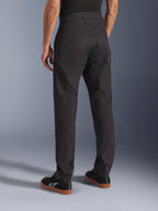 Alpinestars Flex-AST Canvas Pants, nero, vista posteriore che mostra il design workwear heritage con grandi tasche posteriori, vestibilità ergonomica urban riding, indossati con sneaker Alpinestars nere.