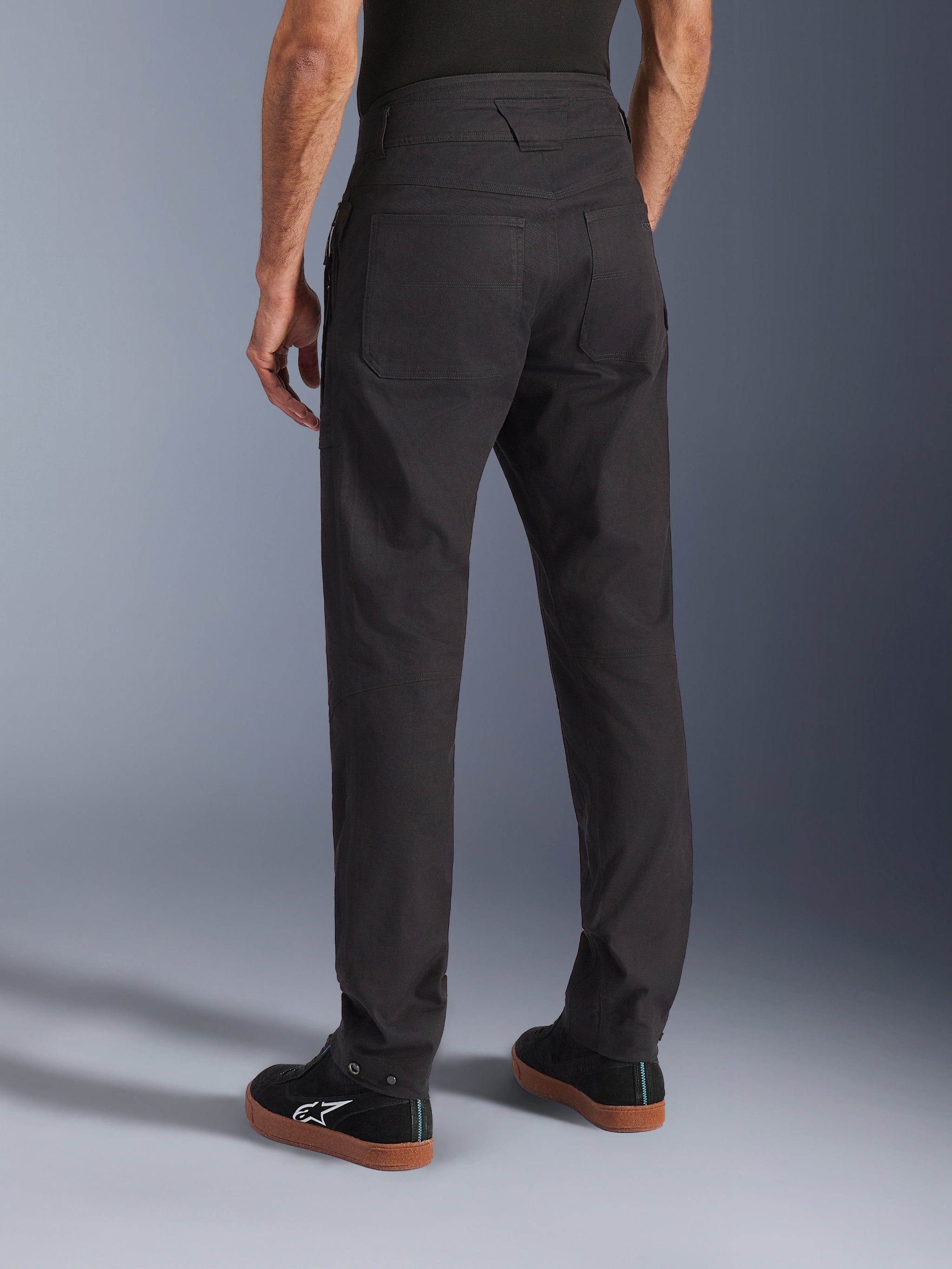 Alpinestars Flex-AST Canvas Pants, Black, rear view showing heritage workwear design with large back pockets, ergonomic urban riding fit, worn with black Alpinestars sneakers.