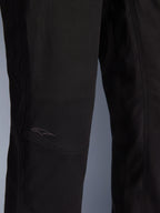 Pantaloni Alpinestars Flex-AST Canvas, pantaloni da moto urbani, nero, primo piano della zona del ginocchio con pannelli preformati e un discreto logo ricamato su tessuto canvas resistente.