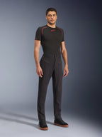 Pantaloni Alpinestars Flex-AST Canvas, pantaloni moto urban, nero, indossati con un base layer nero e sneakers alte casual, caratterizzati da ampie tasche utility con zip e un design ispirato al workwear con vestibilità ergonomica per la guida