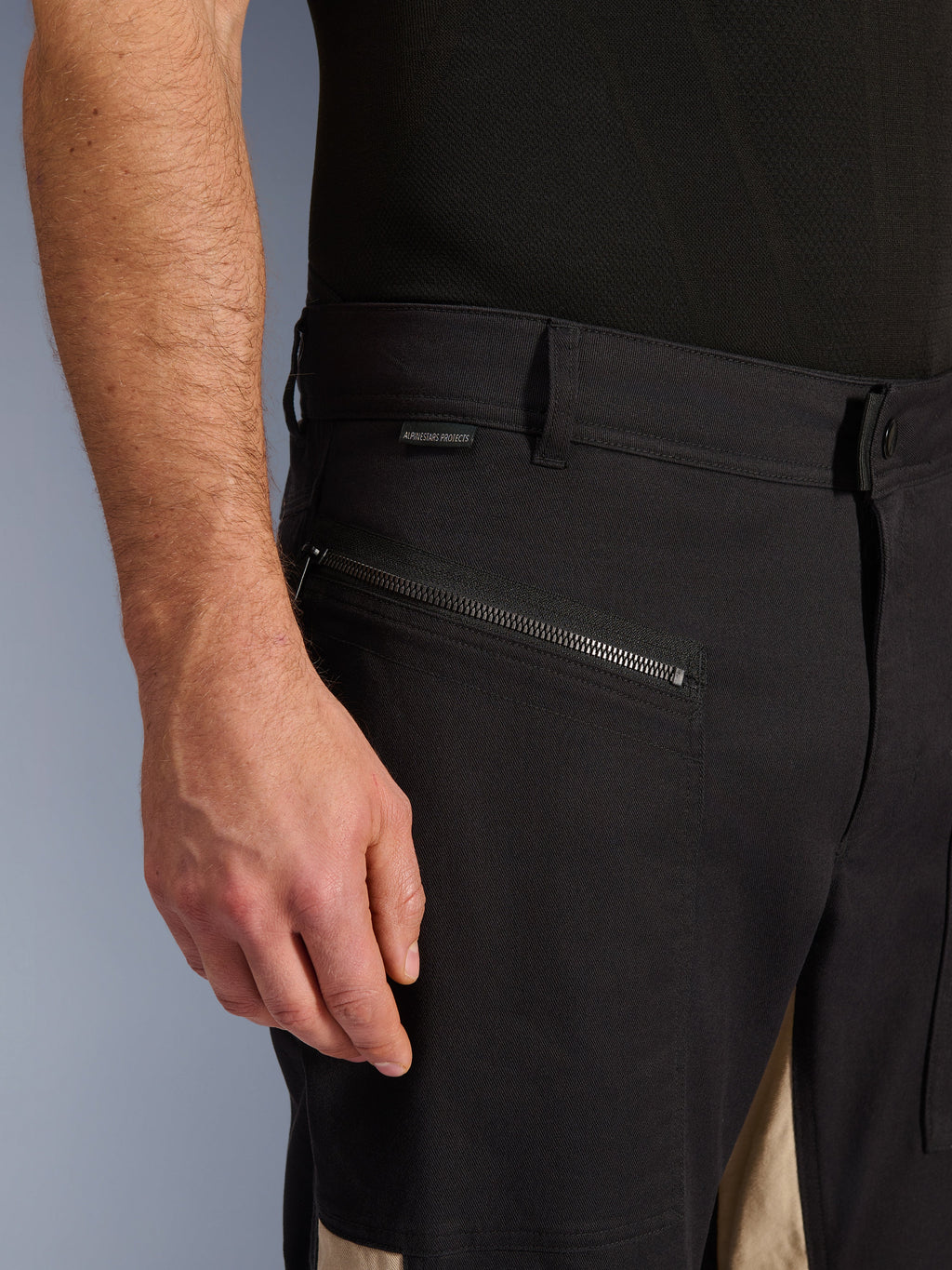 Alpinestars Flex-AST Canvas Pants in Black Aluminum, vista ravvicinata della zona del fianco con tasca orizzontale con zip, passanti per cintura e piccola etichetta del brand, robusta costruzione in policotone elasticizzato per la guida urbana.