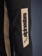 Pantaloni Alpinestars Flex-AST Canvas, dettaglio ravvicinato della gamba laterale, nero con inserto color alluminio, con logo Alpinestars verticale e icona a stella, in resistente twill di policotone per la guida urbana.