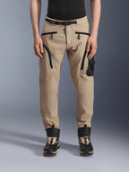 Alpinestars Acteon Pants, pantaloni da moto urban, beige sabbia, con design cargo multitasca, cerniere a spirale inversa nere, cintura integrata e vestibilità affusolata, abbinati a stivali neri e arancioni