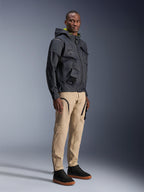 Pantaloni Alpinestars Acteon, pantaloni da moto urban, color sabbia, indossati da un modello con una giacca tecnica scura e sneakers nere, caratterizzati da una vestibilità affusolata con dettagli di cerniere nere e tasche cargo, design contemporaneo ispirato al motorsport