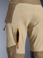 Alpinestars Maxdura Dual Pants in Walnut Aluminum, dettaglio ravvicinato della presa d'aria sulla coscia con cerniera, bordo arancione e rete nera, tessuto in poliammide elasticizzata marrone e sabbia con tiranti rossi