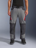 Pantaloni Alpinestars Maxdura Dual, pantaloni da moto adventure, grigio scuro e grigio intenso con accenti rossi, vista frontale che mostra le prese d'aria con cerniera sulle cosce, cintura con fibbia magnetica e pannelli rinforzati sulle ginocchia, design over-boot per guida dual-sport.