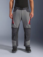 Pantaloni Alpinestars Maxdura Dual, pantaloni da moto adventure, grigio scuro e grigio intenso con accenti rossi, vista frontale che mostra le prese d'aria con cerniera sulle cosce, cintura con fibbia magnetica e pannelli rinforzati sulle ginocchia, design over-boot per guida dual-sport.