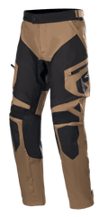 Alpinestars Venture XT Pants Over Boot, pantaloni da moto adventure touring, marrone e nero, con pannelli rinforzati su ginocchia e cosce, tasca cargo laterale con logo Alpinestars e cinturino in vita regolabile.