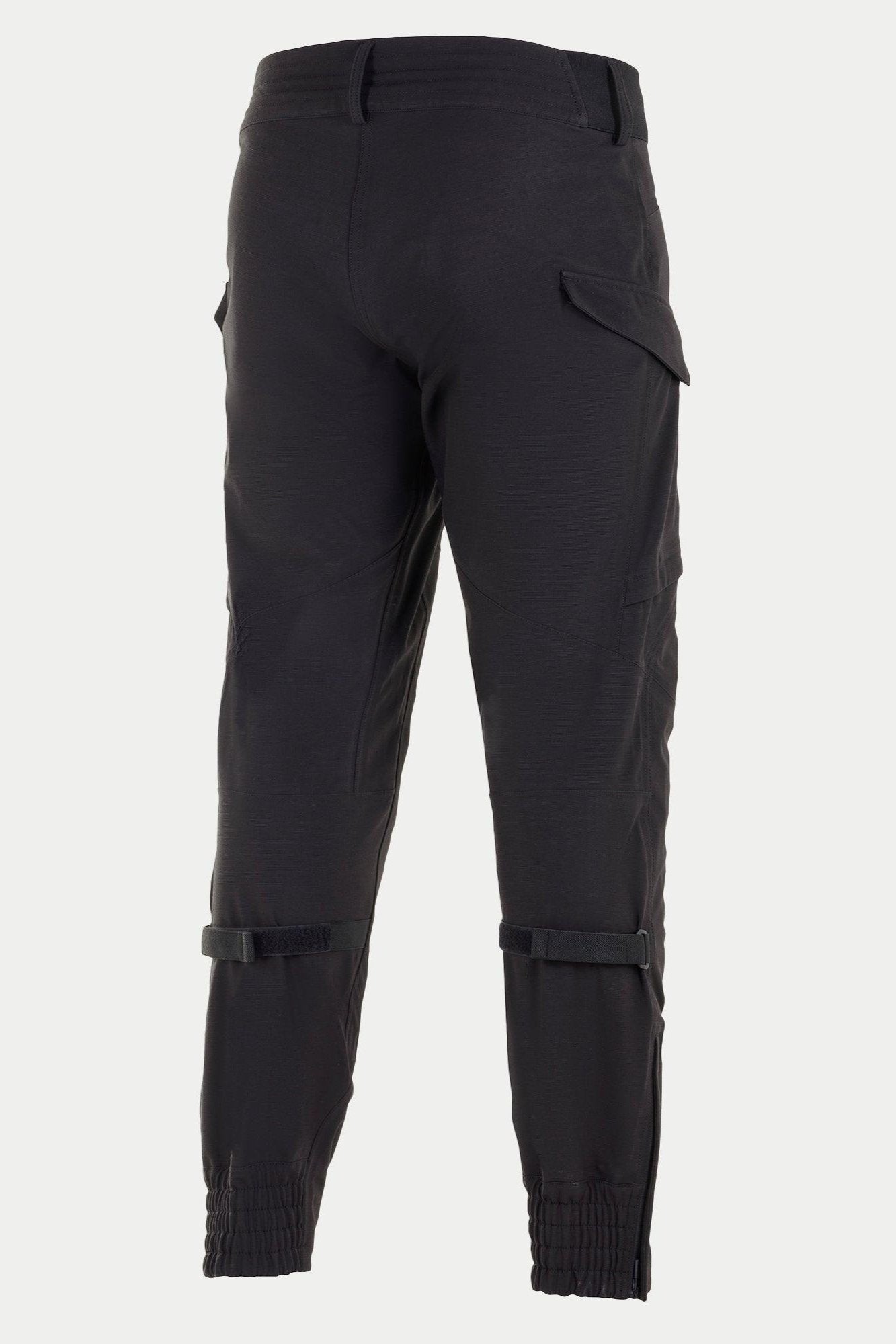 Pantaloni Alpinestars Juggernaut Waterproof, pantaloni da moto neri, vista posteriore con polsini elasticizzati alle caviglie, regolatori di volume sul polpaccio e tasche cargo, costruzione in softshell 3L per guida urbana e su strada