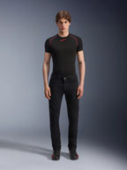 Pantaloni Alpinestars Copper V3 Denim in Black Rinse, vestibilità regular comfort a gamba dritta, indossati da un modello con t-shirt base layer nera con cuciture rosse a contrasto e sneakers da moto nere, completo da motociclismo urbano