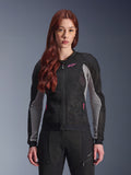 Giacca Alpinestars Stella Troop-Air da donna, giacca da moto traforata, nero, grigio cenere e rosa fluo, indossata da una modella con pantaloni coordinati, costruzione in mesh tecnico 2D ventilato e dettagli del logo rosa, ideale per la guida urbana estiva